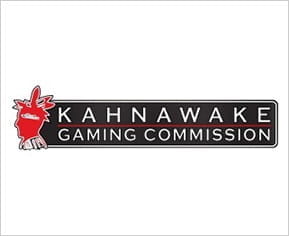 Image with the logo of the Kahnawake Gaming Commission. On the left, the silhouette in red of a man with a plume of feathers.